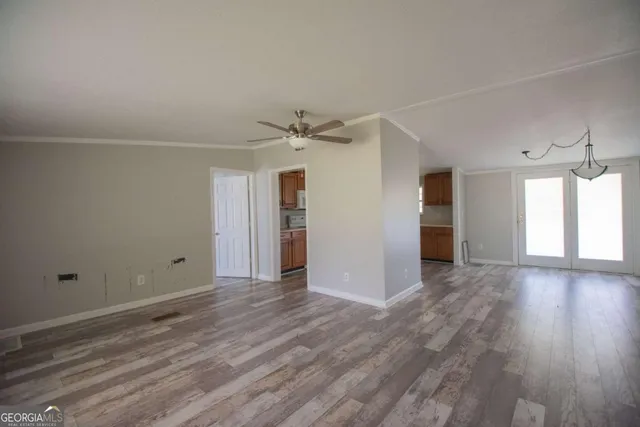 a view of a livingroom with wooden floor and a ceiling fan