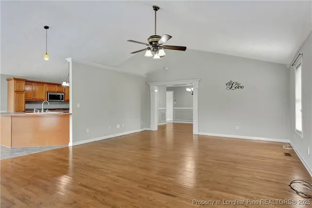 a view of empty room with wooden floor and window
