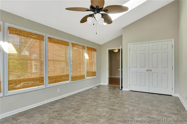 an empty room with wooden floor chandelier fan and closet