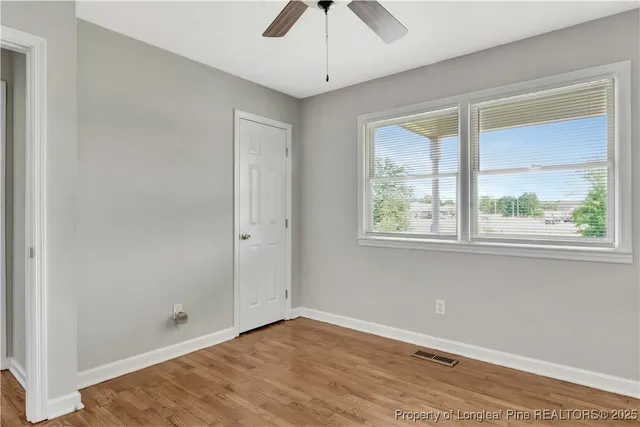 a view of an empty room with wooden floor