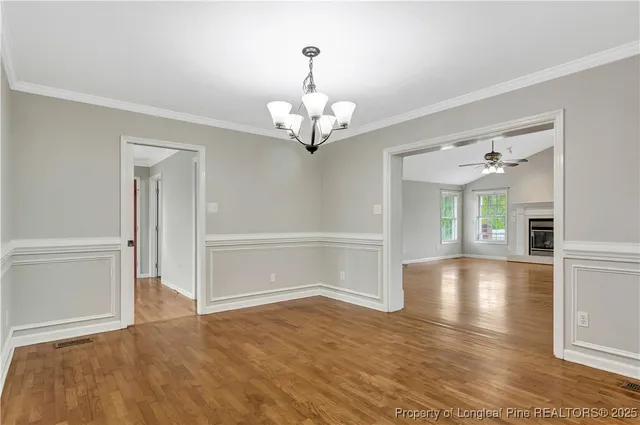 a view of a livingroom with wooden floor and a chandelier