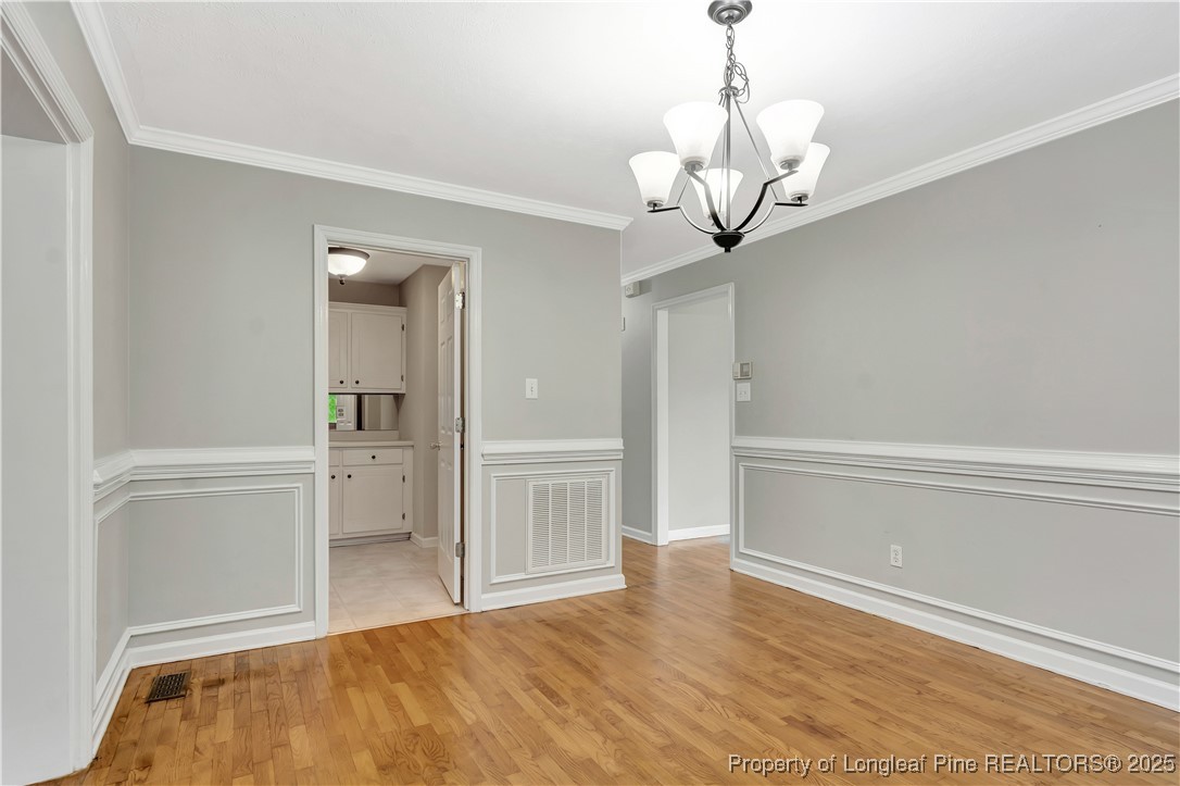 6036-6070 Camden Road Fayetteville, NC 28306 - Photo 10 of 45 a view of a livingroom with wooden floor and a chandelier