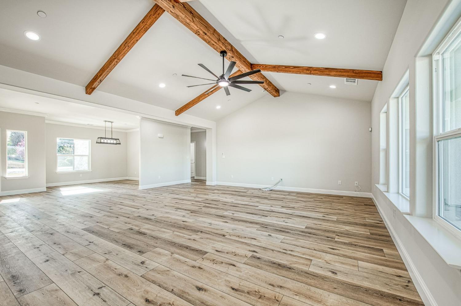 11271 Mountain View Drive Madera, CA 93636 - Photo 20 of 73 en empty room with wooden floor ceiling fan and windows