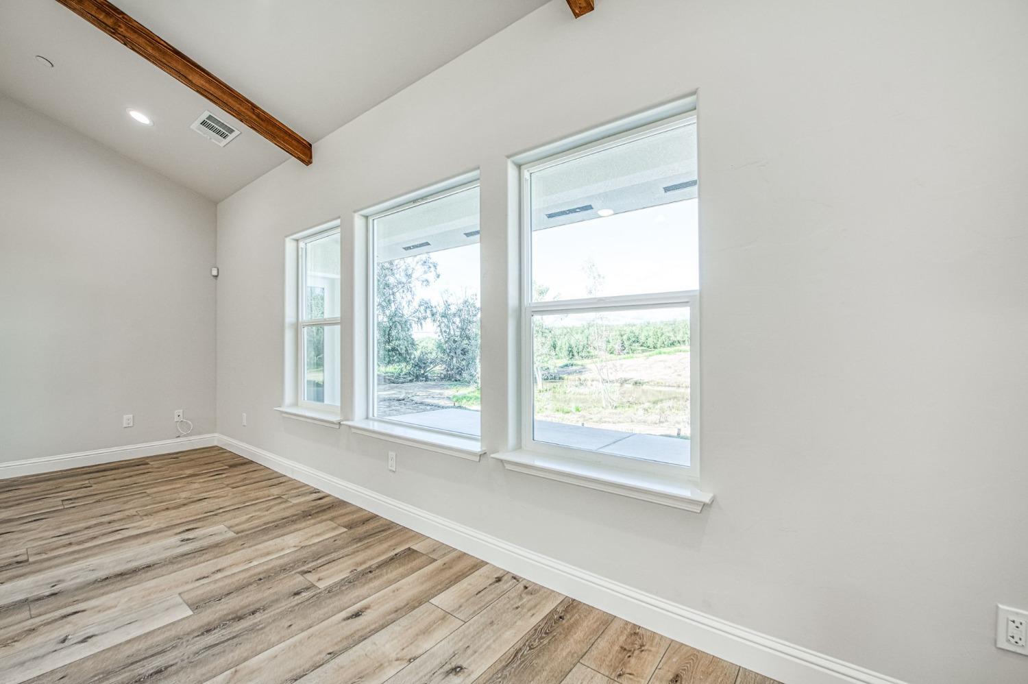 11271 Mountain View Drive Madera, CA 93636 - Photo 39 of 73 a view of an empty room with wooden floor and a window