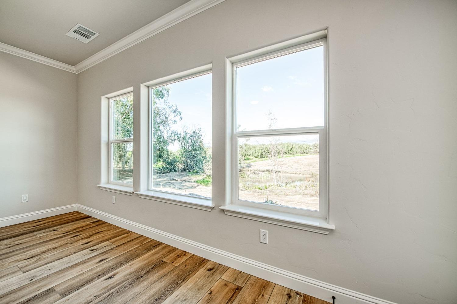 11271 Mountain View Drive Madera, CA 93636 - Photo 45 of 73 a view of an empty room with wooden floor and a window