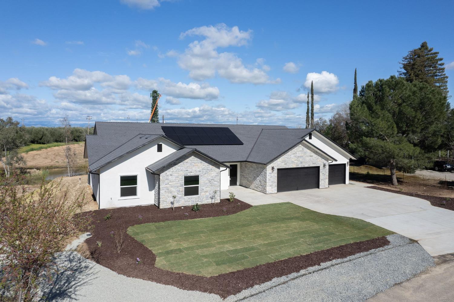 11271 Mountain View Drive Madera, CA 93636 - Photo 50 of 73 a view of a white house with a big yard and potted plants
