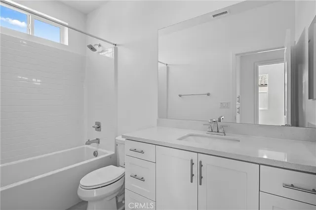 a bathroom with a sink toilet vanity granite tub and shower
