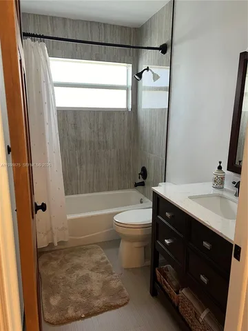 a bathroom with a sink a toilet a mirror and shower