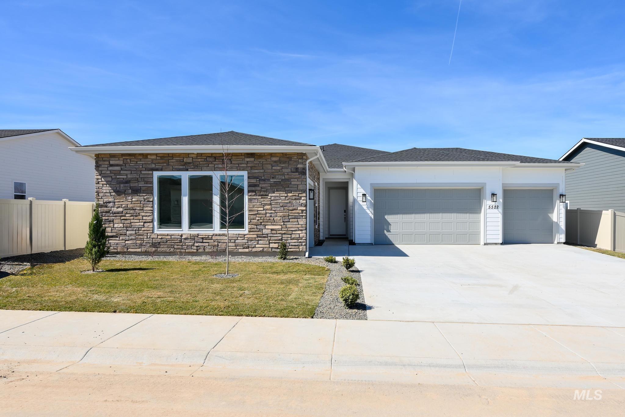 5324 Sparky Avenue Caldwell, ID 83607 - Photo 1 of 10 View of front facade with driveway, a garage, stone siding, and a shingled roof