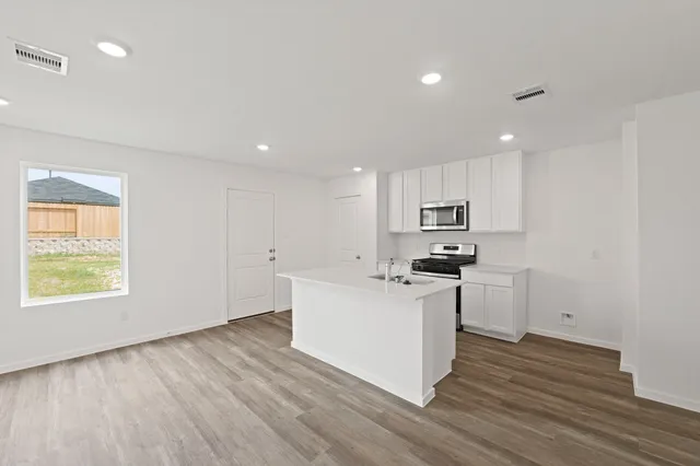 a kitchen with stainless steel appliances granite countertop a stove a sink and a refrigerator