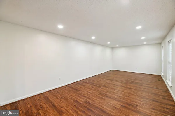 a view of an empty room and chandelier fan