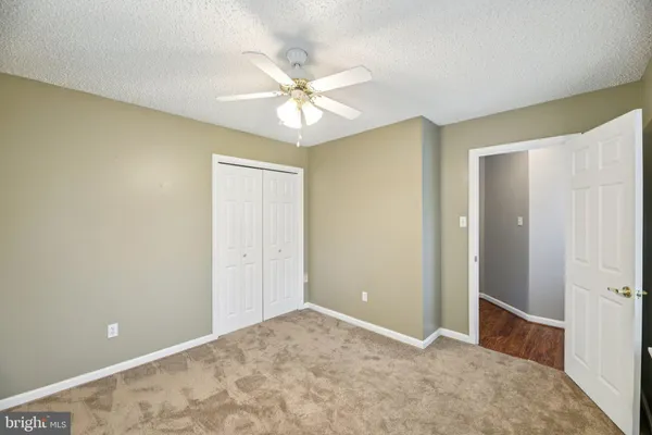 a view of a room with a ceiling fan and window