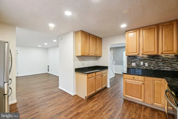 a kitchen with granite countertop a refrigerator and a sink