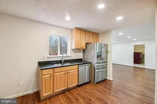 a kitchen with granite countertop a stove a sink and a microwave
