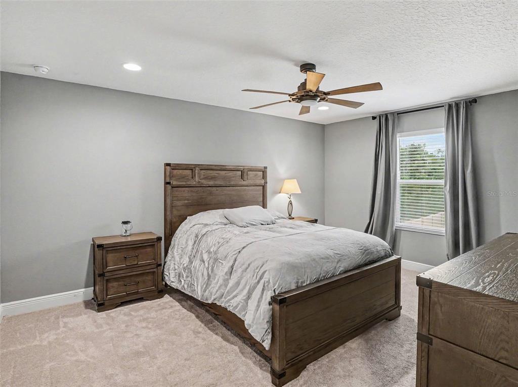 5270 Obsidian Gate Road Mount Dora, FL 32757 - Photo 33 of 50 a bedroom with a bed and a ceiling fan