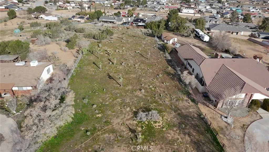 an aerial view of a residential houses with yard