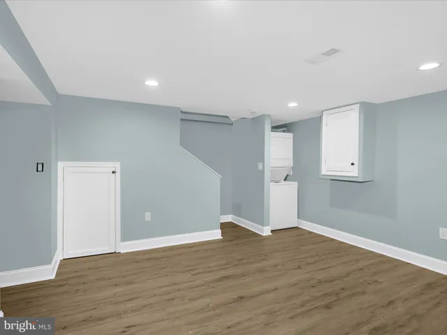 a view of empty room with wooden floor and window