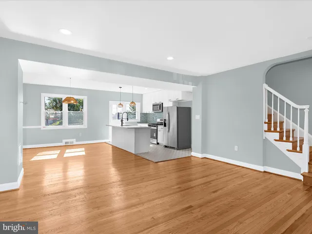 a view of empty room with wooden floor and plants