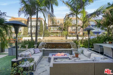 a backyard of a house with garden and outdoor seating