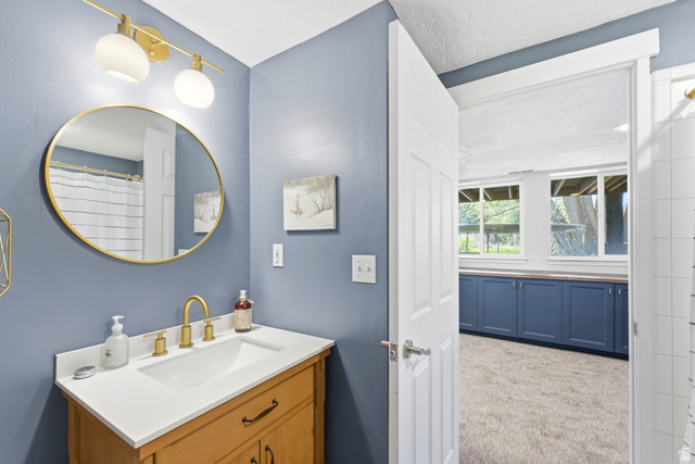 7935 Mustang Loop Road Park City, UT 84098 - Photo 34 of 60 Bathroom featuring a light wood-finish vanity with a white countertop and gold-tone faucet