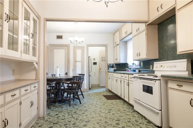a kitchen with white cabinets and white appliances