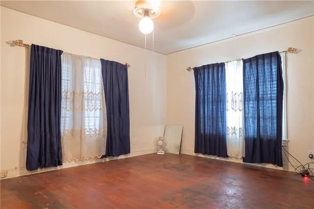 an empty room with windows and closet area