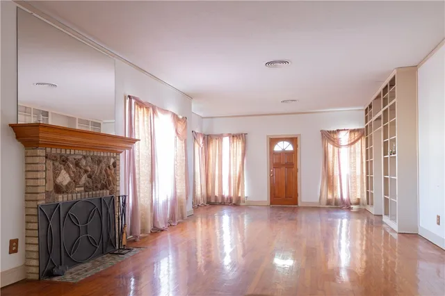 a view of a hallway with wooden floor and fireplace