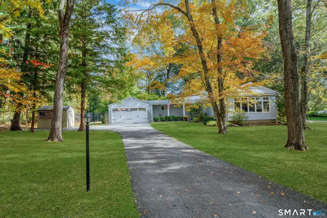 a front view of a house with a yard and trees