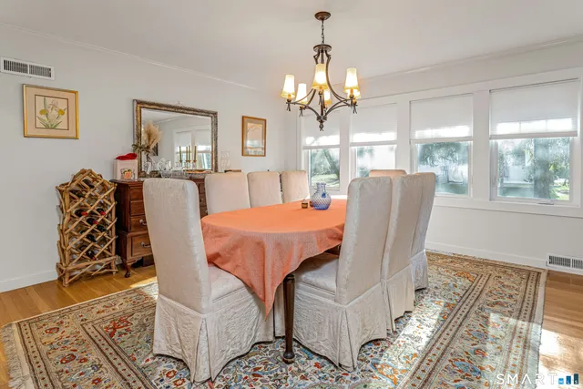 a view of a dining room with furniture a chandelier and wooden floor