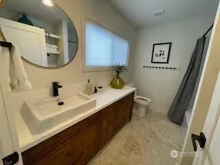 a bathroom with a double vanity sink mirror and toilet