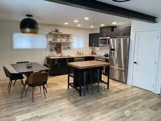 219 East Main Mossyrock, WA 98564 - Photo 2 of 28 a kitchen with stainless steel appliances a stove a refrigerator and a dining table with wooden floor