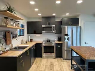 219 East Main Mossyrock, WA 98564 - Photo 4 of 28 a kitchen with stainless steel appliances granite countertop a sink stove microwave and refrigerator