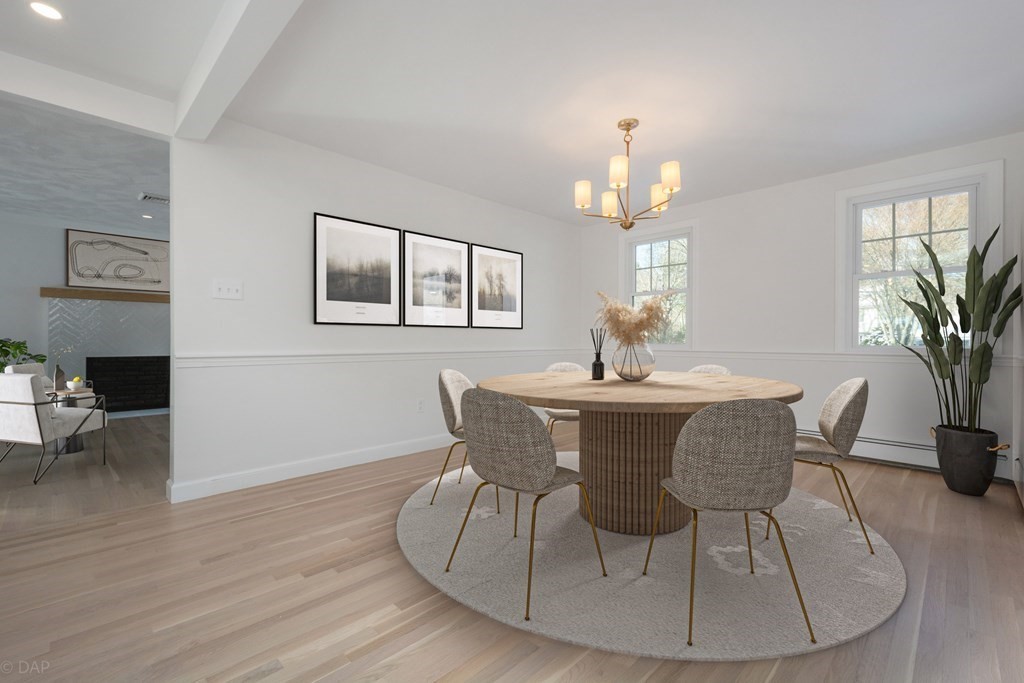 143 Hillcrest Road Concord, MA 01742 - Photo 11 of 42 a dining room with furniture a potted plant and wooden floor