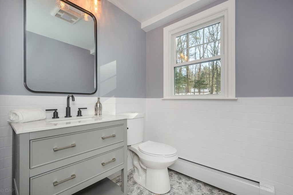 143 Hillcrest Road Concord, MA 01742 - Photo 19 of 42 a bathroom with a toilet a sink a vanity a window and mirror