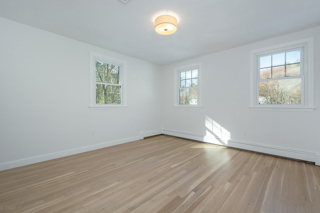 143 Hillcrest Road Concord, MA 01742 - Photo 28 of 42 an empty room with wooden floor and windows
