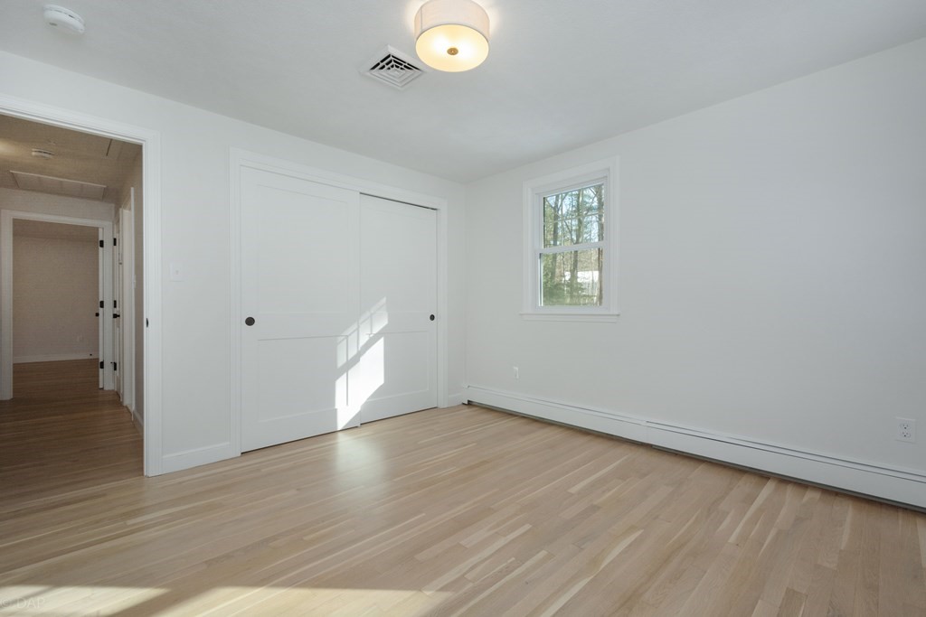 143 Hillcrest Road Concord, MA 01742 - Photo 31 of 42 an empty room with wooden floor and windows