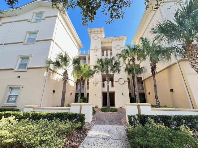 a view of a white house with a yard and potted plants