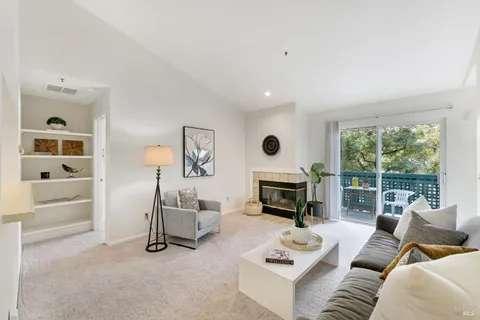 a living room with furniture a fireplace and a window