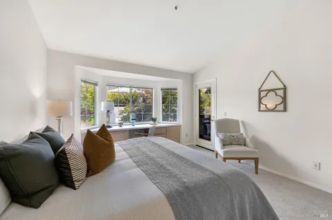 a spacious bedroom with a bed and large windows