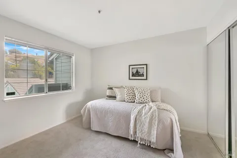 a bedroom with a bed and a large window