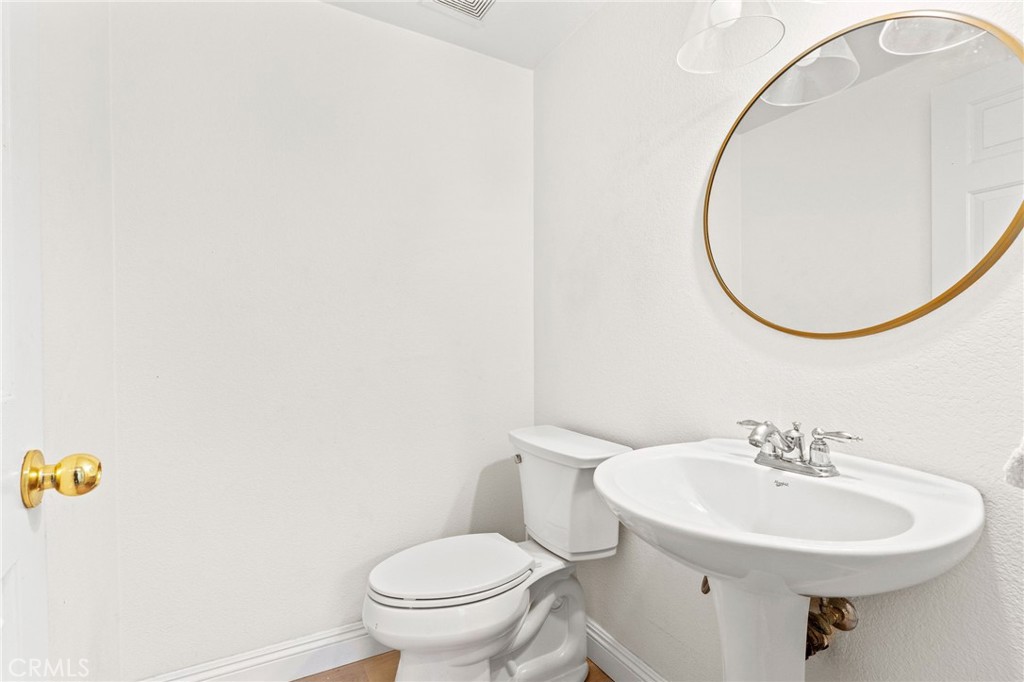 29225 Hydrangea Street Murrieta, CA 92563 - Photo 12 of 38 a bathroom with a sink a toilet and mirror