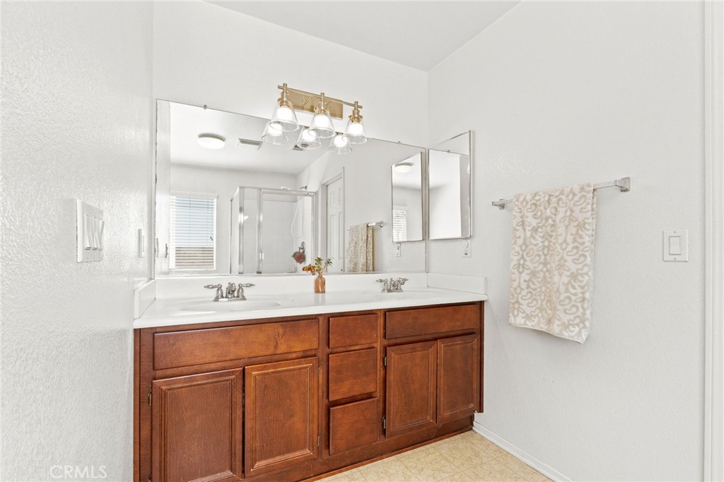 29225 Hydrangea Street Murrieta, CA 92563 - Photo 22 of 38 a bathroom with a double vanity sink and a mirror