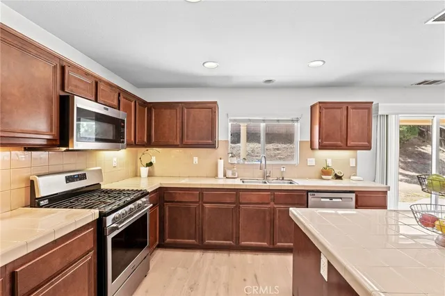 a kitchen with stainless steel appliances granite countertop a sink stove microwave and cabinets