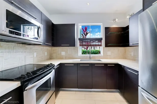 a kitchen with stainless steel appliances a sink stove and microwave