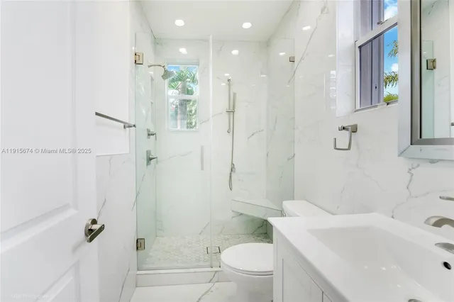 a bathroom with a sink toilet vanity and shower