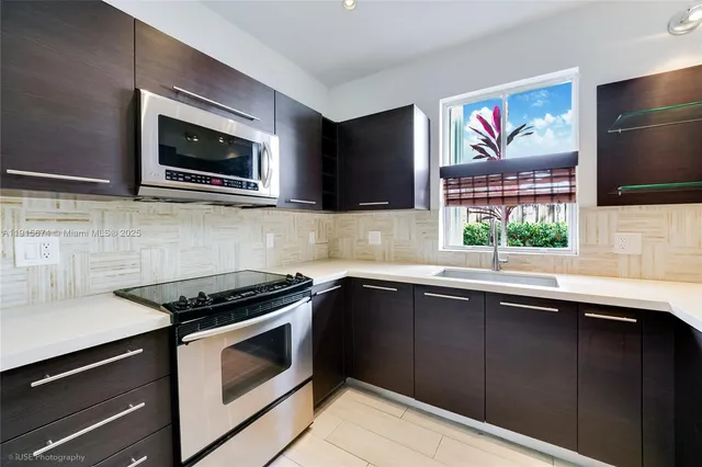 a kitchen with stainless steel appliances a stove microwave and sink