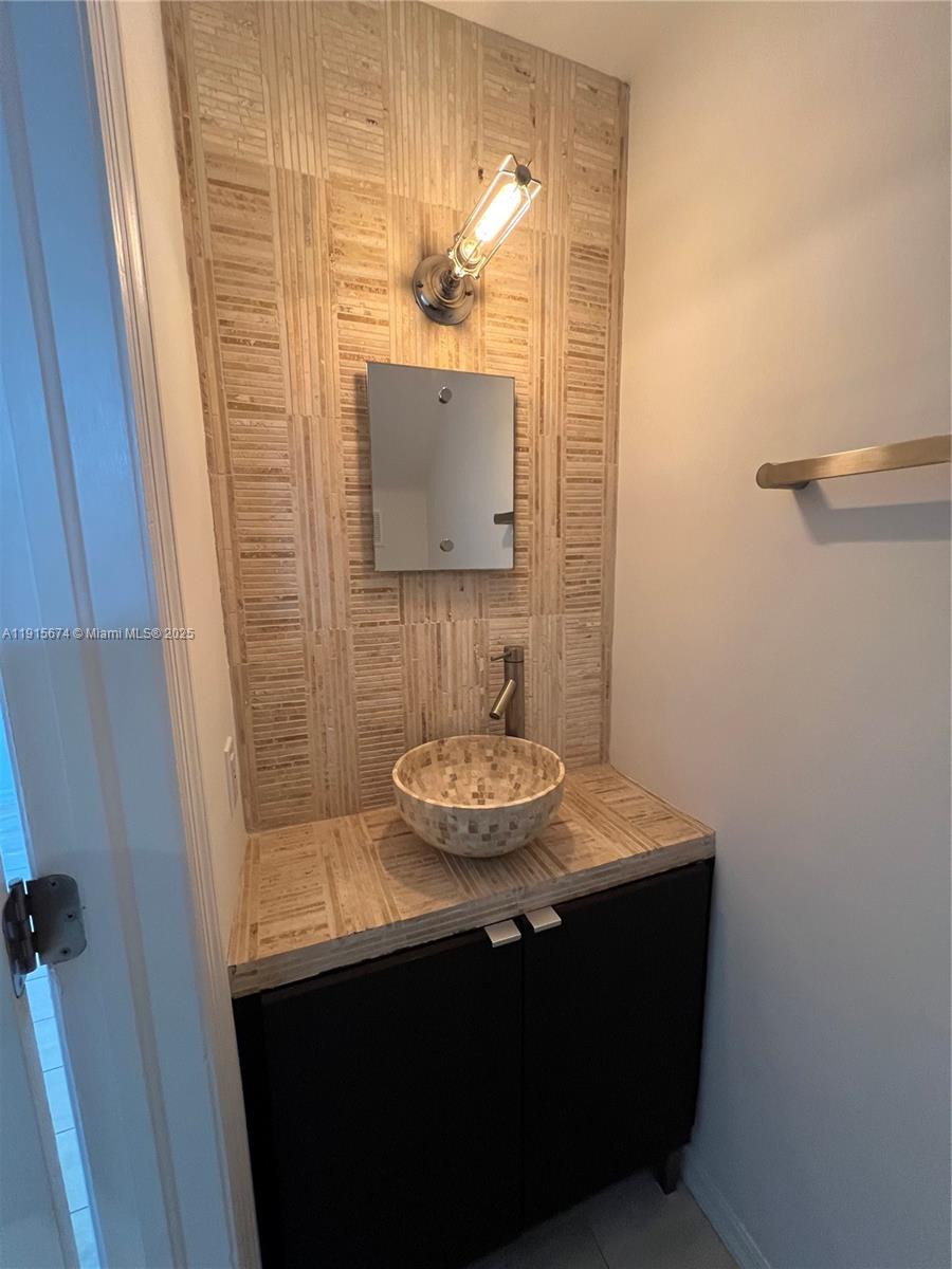 2970 Bird Avenue, Unit 15 Miami, FL 33133 - Photo 6 of 18 a bathroom with a sink and a mirror