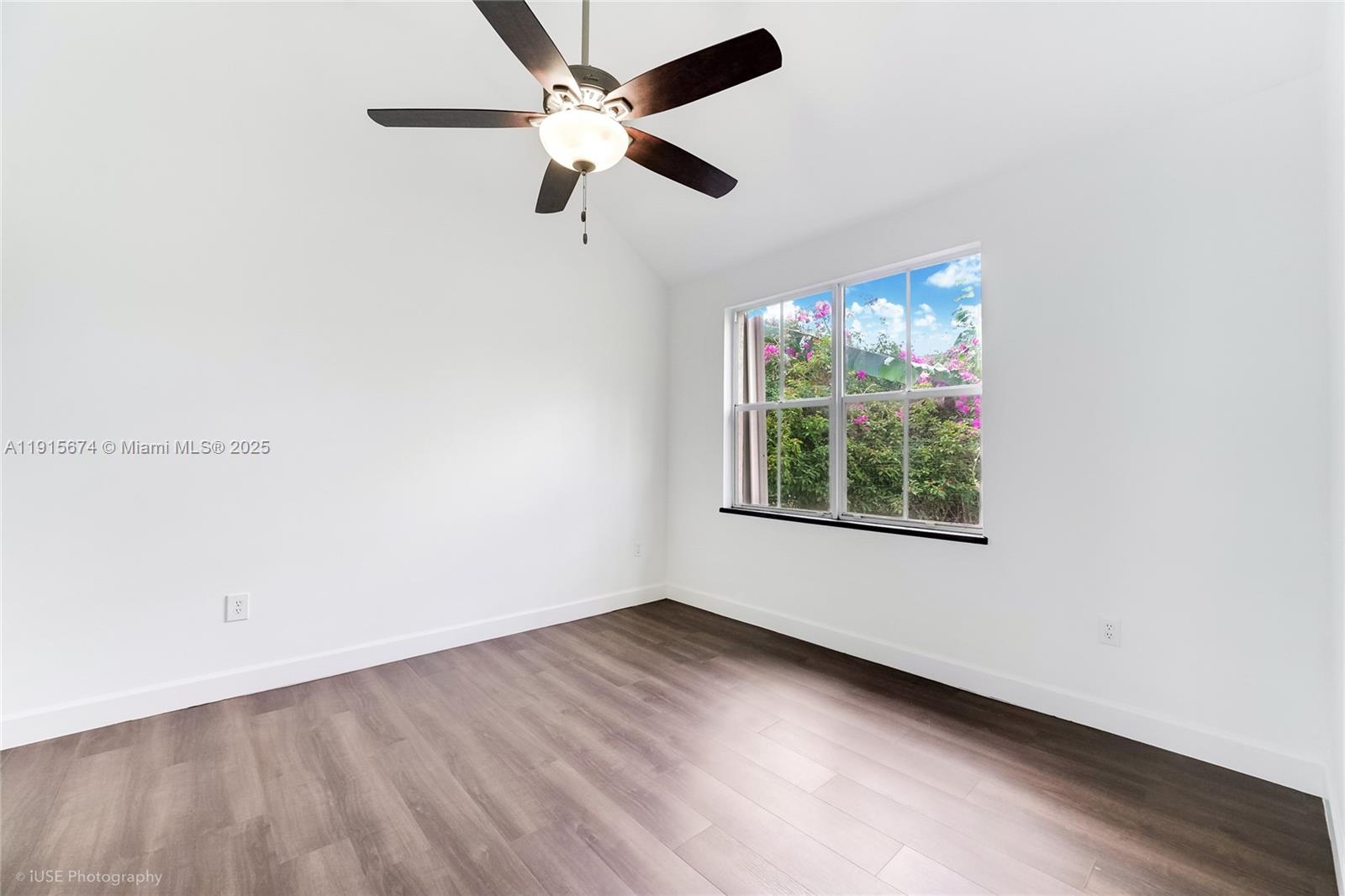 2970 Bird Avenue, Unit 15 Miami, FL 33133 - Photo 8 of 18 an empty room with wooden floor fan and windows