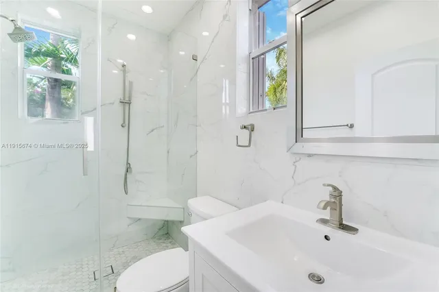 a bathroom with a sink a toilet and shower