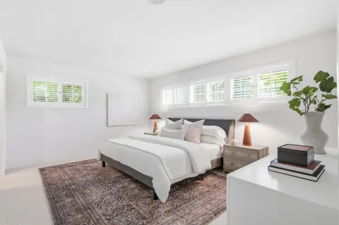 a bedroom with bed and a potted plant